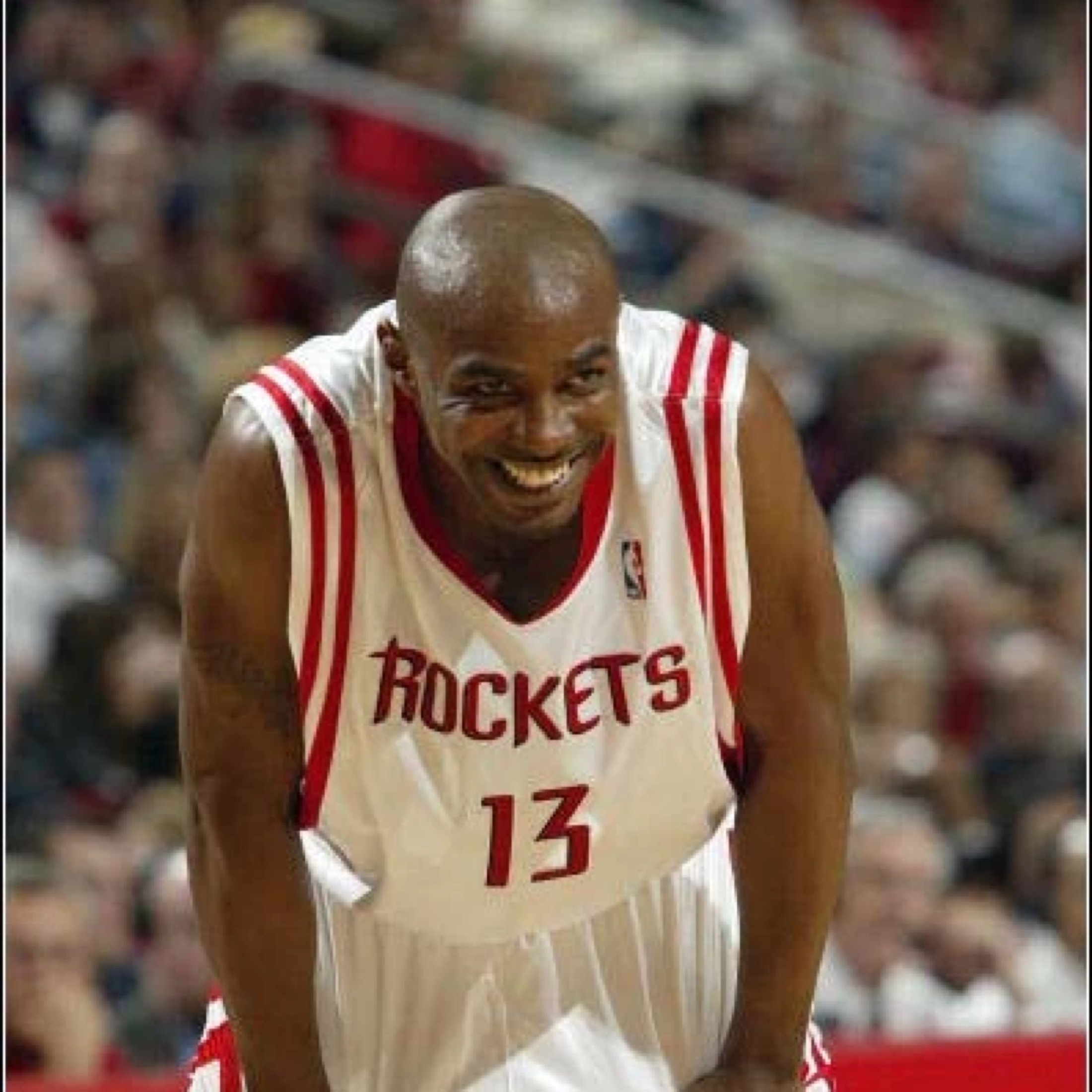 Mike James smiling in a Houston Rockets jersey during his NBA career.